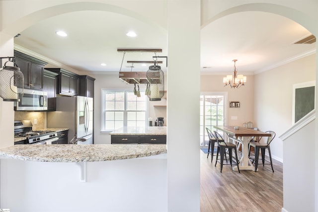 110 Avendell Dr, Easley, SC 29642 - kitchen with appliances with stainless steel finishes, crown molding, wood finished floors, plenty of natural light, and arched walkways