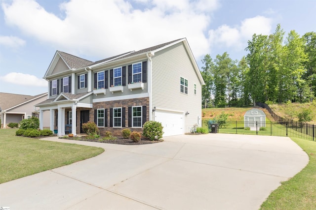 110 Avendell Dr, Easley, SC 29642 - view of front facade featuring concrete driveway, stone siding, an attached garage, a storage unit, and an outdoor structure
