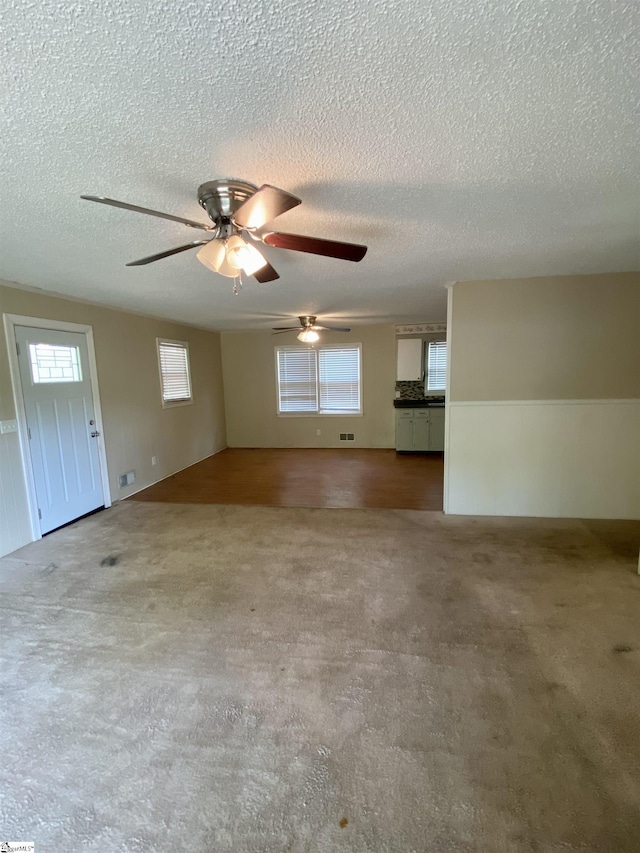 6 Powell Cir, Inman, SC 29349 - unfurnished living room with a textured ceiling, a ceiling fan, carpet, and a wainscoted wall