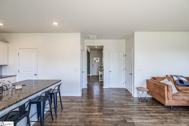 115 Slateford Cir, Piedmont, SC 29673 - kitchen with a kitchen bar, dark wood-style floors, white cabinetry, dark stone counters, and baseboards