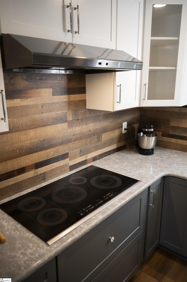 105 Bitternut Ln, Taylors, SC 29687 - kitchen featuring black electric cooktop, under cabinet range hood, white cabinetry, dark wood-style flooring, and light stone countertops