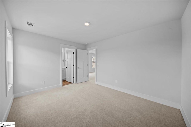 unfurnished bedroom featuring carpet flooring, baseboards, connected bathroom, and recessed lighting