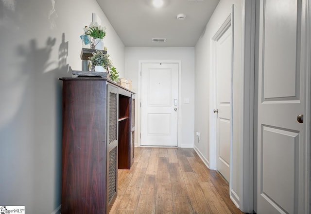 hallway featuring hardwood / wood-style flooring and baseboards