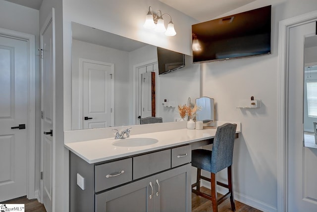 bathroom with vanity, wood finished floors, and baseboards