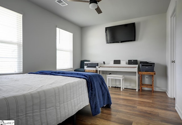 bedroom featuring hardwood / wood-style floors, a ceiling fan, and baseboards