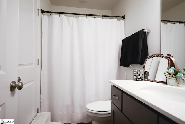 full bathroom featuring toilet, vanity, and curtained shower