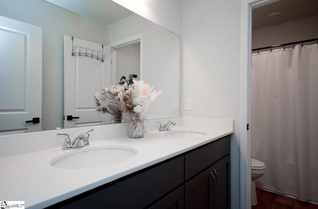 full bath with toilet, double vanity, wood finished floors, and a shower with curtain