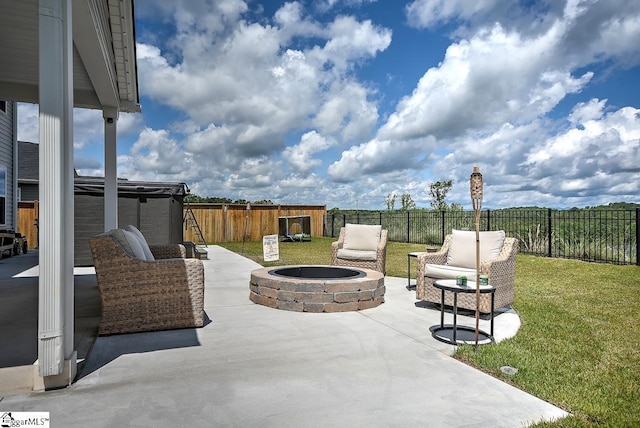view of patio with an outdoor living space with a fire pit