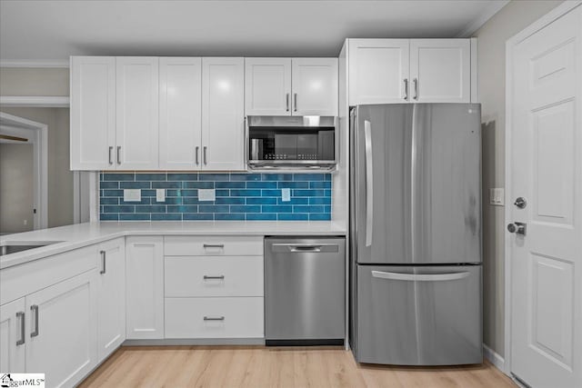 2575 Old Ansel School Rd, Greer, SC 29651 - kitchen with stainless steel appliances, light countertops, white cabinets, decorative backsplash, and ornamental molding