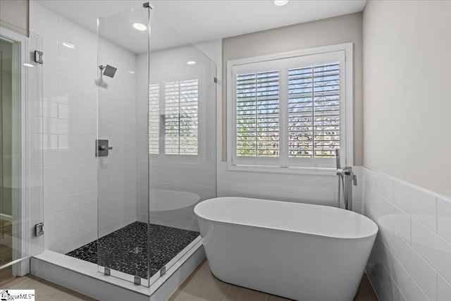 2575 Old Ansel School Rd, Greer, SC 29651 - bathroom featuring tile walls, a shower stall, a freestanding tub, and recessed lighting