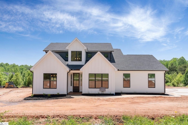 view of front of house with board and batten siding and a shingled roof