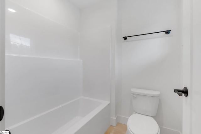 bathroom with toilet, baseboards, tile patterned flooring, and shower / tub combination