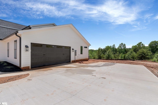 view of side of home featuring concrete driveway