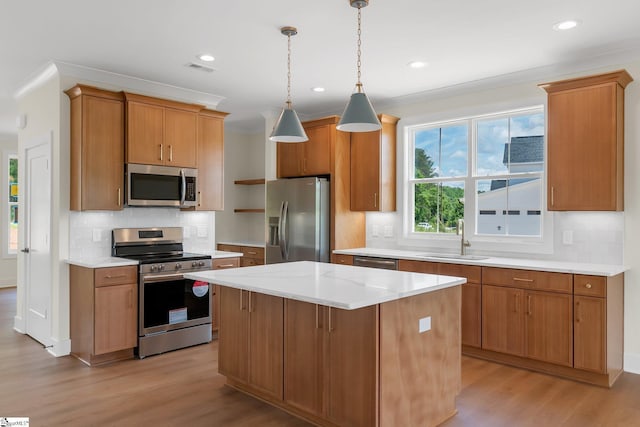 kitchen featuring appliances with stainless steel finishes, a sink, light wood finished floors, tasteful backsplash, and recessed lighting
