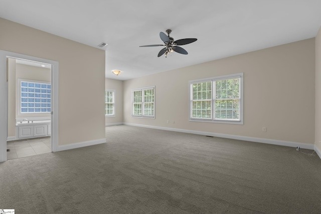 spare room with carpet flooring, ceiling fan, and baseboards