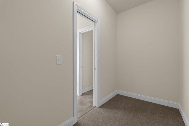 hall featuring light carpet and baseboards