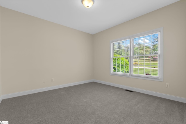 carpeted empty room featuring baseboards
