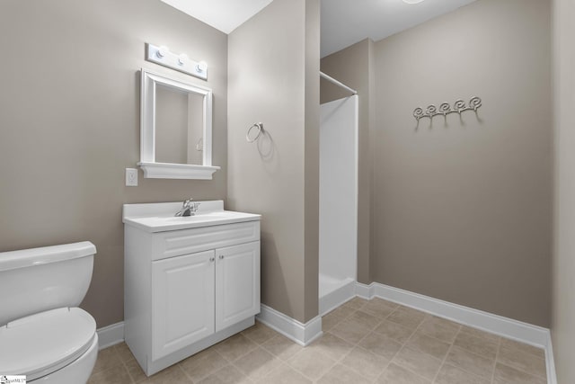 bathroom featuring a shower, toilet, vanity, and baseboards