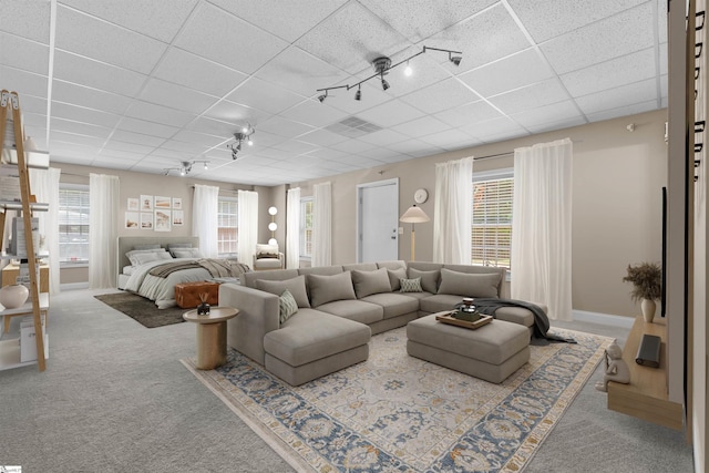 living area featuring carpet flooring, a paneled ceiling, and baseboards
