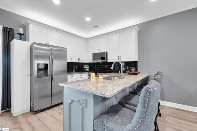 40 Ridgestone Cir, Mauldin, SC 29662 - kitchen featuring stainless steel appliances, light stone counters, a peninsula, decorative backsplash, and light wood-style floors