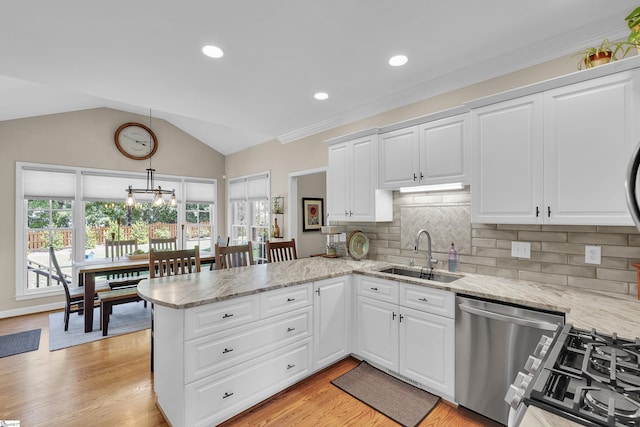 kitchen featuring a sink, stainless steel dishwasher, a peninsula, light stone counters, and backsplash