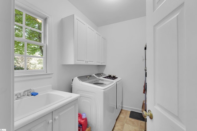 washroom with cabinet space, washer and clothes dryer, and baseboards