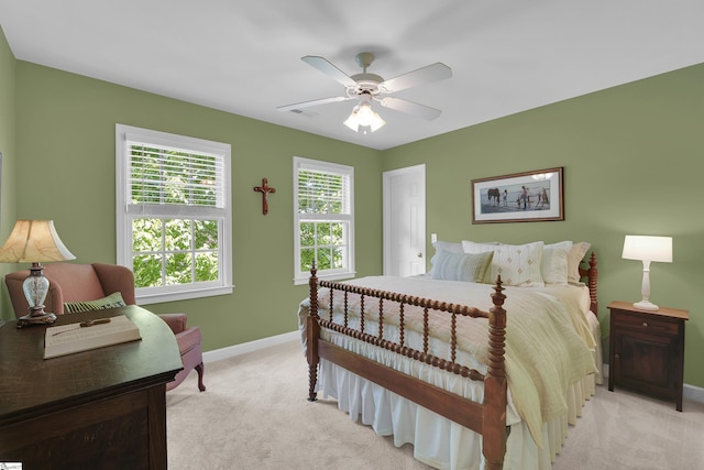 bedroom featuring light colored carpet, baseboards, and ceiling fan