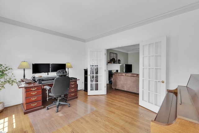 home office with french doors, ornamental molding, light wood-style floors, a fireplace, and baseboards