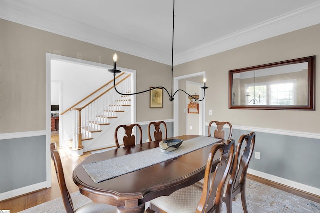 dining space featuring stairs, wood finished floors, and crown molding