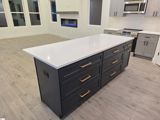 402 Edgewater Dr, Anderson, SC 29626 - kitchen with appliances with stainless steel finishes, light wood-style floors, light countertops, a kitchen island, and gray cabinetry