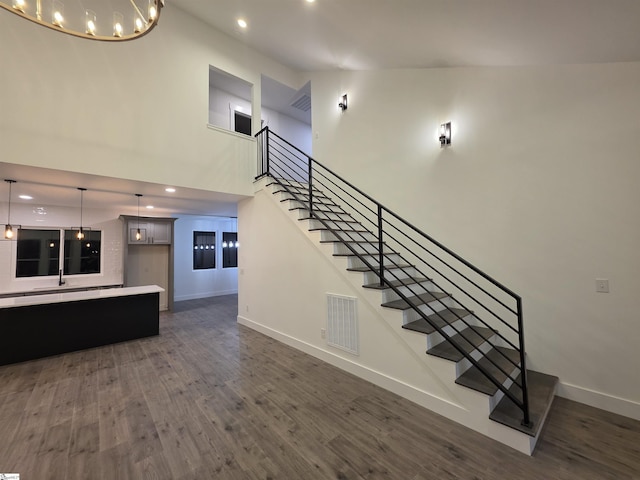 402 Edgewater Dr, Anderson, SC 29626 - stairway featuring baseboards, wood finished floors, a chandelier, a high ceiling, and recessed lighting