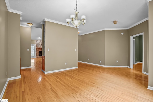 1298 Moorehead Pl, Pendleton, SC 29670 - empty room featuring light wood-type flooring, a chandelier, crown molding, baseboards, and a stone fireplace