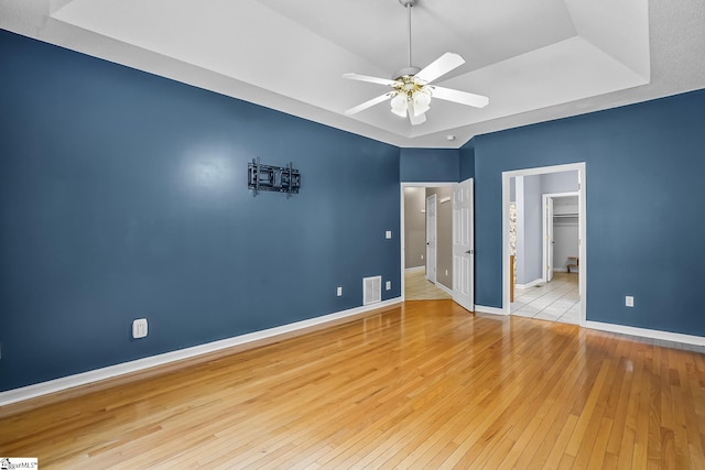 1298 Moorehead Pl, Pendleton, SC 29670 - unfurnished bedroom featuring baseboards, wood-type flooring, a raised ceiling, a walk in closet, and a ceiling fan