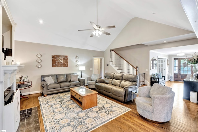 living room with stairs, ceiling fan, high vaulted ceiling, a fireplace with flush hearth, and recessed lighting