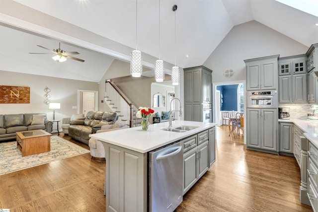 kitchen with gray cabinets, a sink, high vaulted ceiling, stainless steel appliances, and ceiling fan