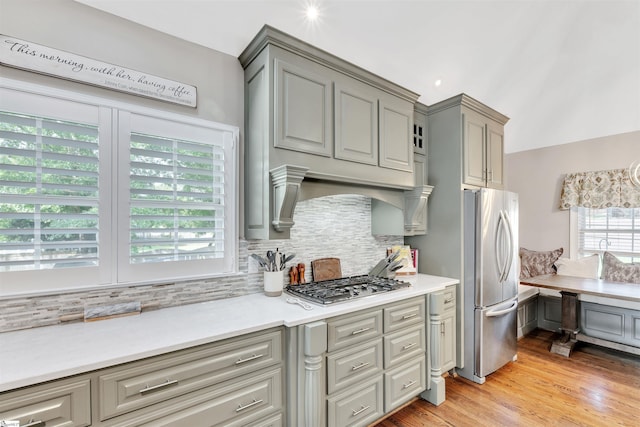 kitchen featuring stainless steel appliances, gray cabinetry, decorative backsplash, and light countertops