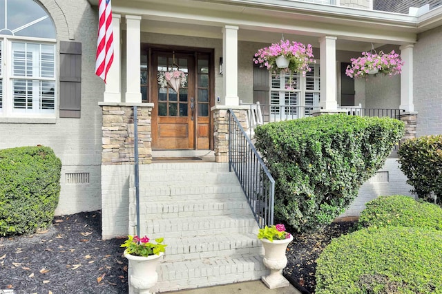 property entrance featuring a porch and stone siding