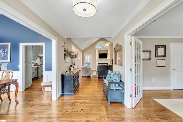 corridor with light wood-style floors, ornamental molding, baseboards, and lofted ceiling