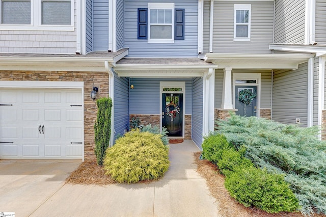305 Yellow Fox Rd, Greer, SC 29650 - view of exterior entry featuring stone siding, an attached garage, concrete driveway, and a porch