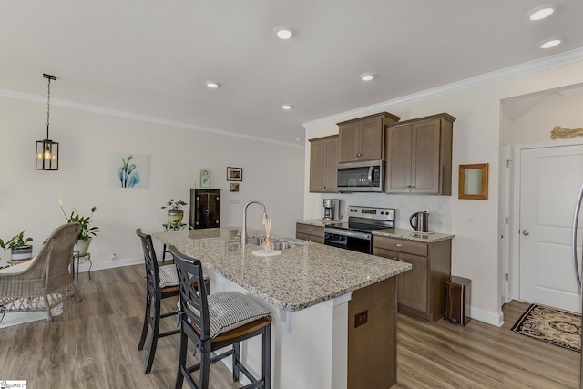 305 Yellow Fox Rd, Greer, SC 29650 - kitchen with appliances with stainless steel finishes, a sink, wood finished floors, an island with sink, and crown molding