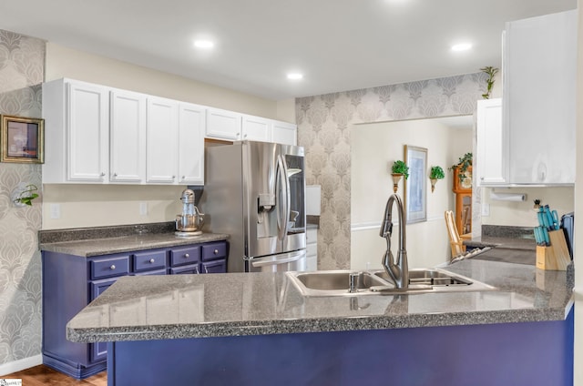 239 Walcott Dr, Lyman, SC 29365 - kitchen with wallpapered walls, stainless steel fridge, a sink, blue cabinetry, and white cabinets