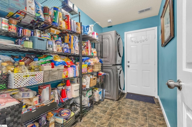 239 Walcott Dr, Lyman, SC 29365 - laundry area featuring stacked washer and clothes dryer, baseboards, and a textured ceiling