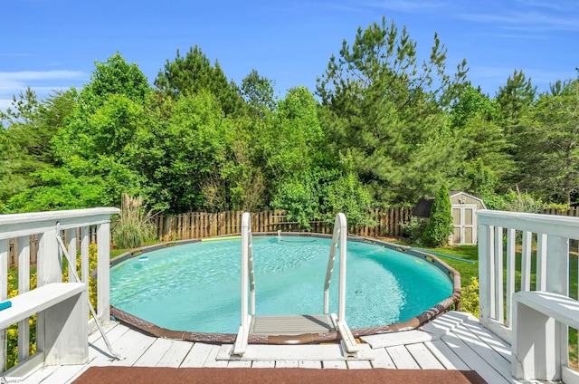 239 Walcott Dr, Lyman, SC 29365 - view of pool featuring a storage unit, a fenced backyard, an outbuilding, a wooden deck, and view of wooded area