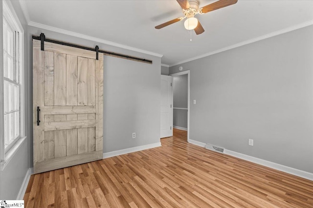 408 Bent Creek Dr, Greer, SC 29650 - unfurnished bedroom with baseboards, crown molding, wood finished floors, a barn door, and a ceiling fan