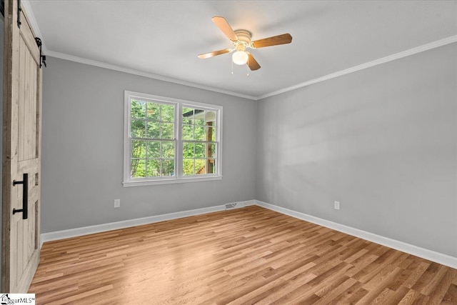 408 Bent Creek Dr, Greer, SC 29650 - unfurnished bedroom featuring ornamental molding, a barn door, light wood finished floors, baseboards, and a ceiling fan