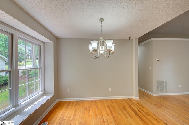 400 Halifax Dr, Greenville, SC 29615 - spare room featuring a chandelier, light wood finished floors, plenty of natural light, baseboards, and a textured ceiling
