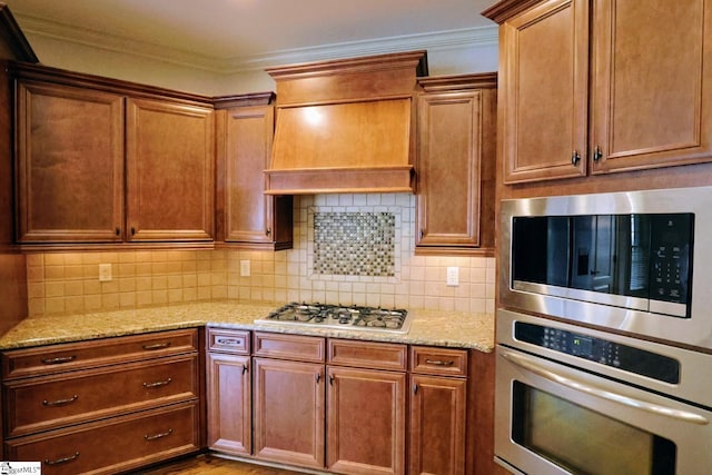 128 Palm Springs Way, Simpsonville, SC 29681 - kitchen with appliances with stainless steel finishes, light stone counters, backsplash, crown molding, and wall chimney range hood