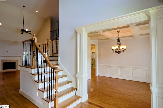 128 Palm Springs Way, Simpsonville, SC 29681 - stairs featuring a chandelier, a fireplace, wood finished floors, coffered ceiling, and beam ceiling