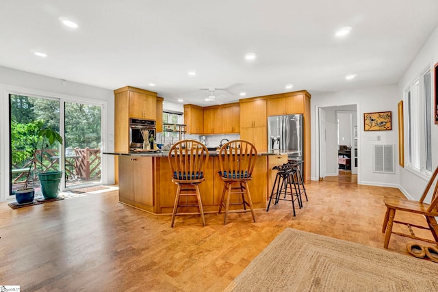 313 Viewmont Dr, Greenville, SC 29609 - kitchen featuring appliances with stainless steel finishes, recessed lighting, a kitchen bar, light wood-type flooring, and a ceiling fan