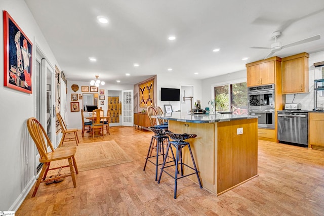 313 Viewmont Dr, Greenville, SC 29609 - kitchen featuring appliances with stainless steel finishes, a breakfast bar area, recessed lighting, a kitchen island with sink, and light wood finished floors